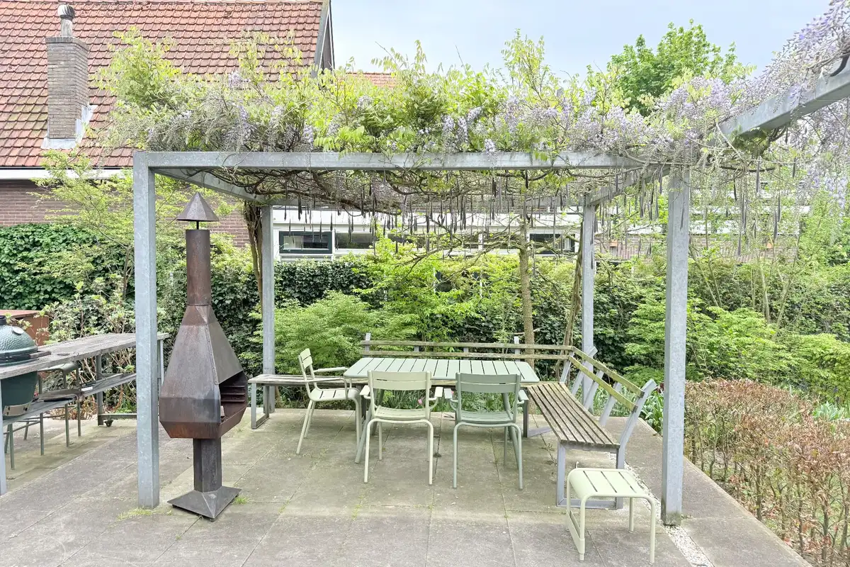 Open stalen pergola frontaal gezien, als open buitenkamer in de tuin